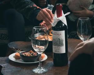 a bottle of wine sitting on a table with a glass at Centro Turístico Anticura Parque Nacional Puyehue in Anticura +11 photos