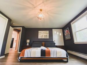 a bedroom with a bed and a chandelier at Centrally Located - 3 Br House in Southington +7 photos