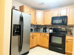 eine Küche mit Holzschränken und einem Edelstahlkühlschrank in der Unterkunft Unit 1606 - Mountain View Condos in Pigeon Forge