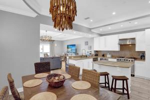 オレンジビーチにあるEscapes to the Shores Penthouse 1803のテーブルと椅子のあるキッチンとダイニングルーム