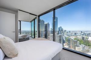 1 dormitorio con cama blanca y ventanas grandes en 2BR Apartment, Panoramic 180 Degrees Views on 52nd Floor, en Melbourne 13 fotos más