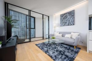 Una sala de estar con un sofá y una mesa de cristal. en 2BR Apartment, Panoramic 180 Degrees Views on 52nd Floor, en Melbourne