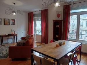 a living room with a wooden table and a couch at Le Clocher in Rouen