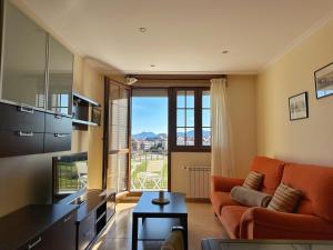a living room with an orange couch and a large window at Cinco Soles - 5927 in Isla