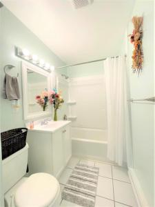 a white bathroom with a toilet and a sink at Pontiac - Secluded Backyard, Pet Friendly in Fort Wayne