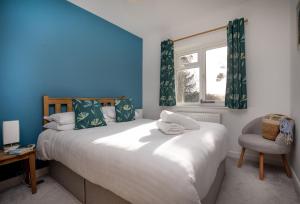 a bedroom with a bed and a chair and a window at Fernwood in Totnes +49 photos