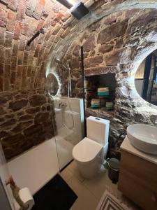 a stone bathroom with a toilet and a sink at Odu The Cellar in Alsóörs