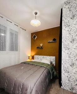 una camera con un letto in una stanza con un muro di M T2 climatisé à100m de la plage ,des bateaux ,des commerces, Une terrasse ensoleillée a Palavas-les-Flots