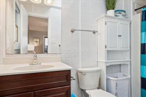 a bathroom with a sink and a toilet and a mirror at KD2033- Ocean Breeze in Kill Devil Hills +24 photos