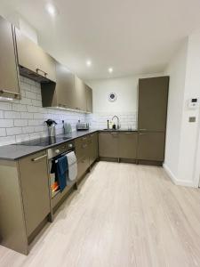a large kitchen with gray cabinets and a wooden floor at Southernhay Court Apartments by Staytor Accommodation in Exeter