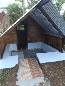 a dog house under a roof with a ramp at Chava Camping Rio Celeste in Rio Celeste