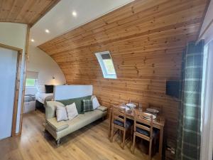 a living room with a couch and a table at Glamping Pod - Vale View in East Heslerton
