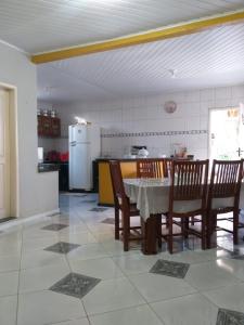Una cocina con mesa y sillas y un refrigerador. en Casa grande com 4 quartos e área de serviços e lazer, en Bragança
