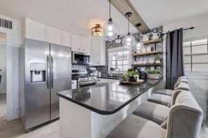 a kitchen with a stainless steel refrigerator and white cabinets at Casa Del Sol - Private Beachfront, Pool Table in Clearwater Beach