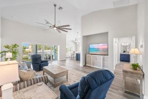 a living room with blue chairs and a tv at Mid Island Beach Getaway - Close to Beach, Heated Pool - Suntide - Roelens in Fort Myers Beach