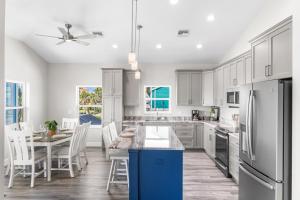 a kitchen with white cabinets and a table and chairs at Mid Island Beach Getaway - Close to Beach, Heated Pool - Suntide - Roelens in Fort Myers Beach