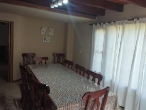 Un comedor con mesa y sillas y una ventana. en Chalet con Piscina exclusiva en el centro de Mar de las Pampas, en Mar de las Pampas 20 fotos más