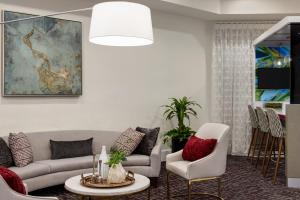 Una sala de estar con un sofá, una mesa y sillas. en Crowne Plaza Orlando - Lake Buena Vista by IHG, en Orlando