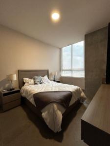 a bedroom with a large bed and a window at Departamento de Lujo, en el centro de Mty in Monterrey