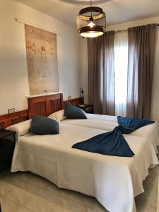 two large beds in a bedroom with a large window at Dulce Mañana in Portomarin