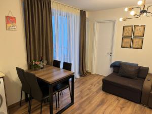 a living room with a dining room table and a couch at Very cozy 2 Room apart NEW GUDAURI, LOFT 2, apt 223 in Gudauri