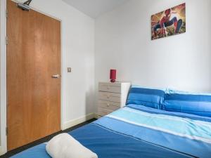 a bedroom with a blue bed and a wooden door at PNJ Long Stay Central Manchester Accommodation in Manchester +3 photos