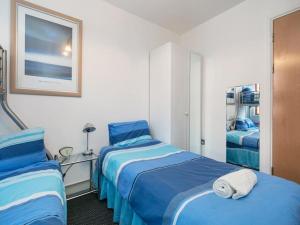 a hotel room with two beds with blue sheets at PNJ Long Stay Central Manchester Accommodation in Manchester