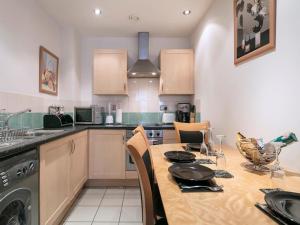 a kitchen with a table with chairs and a sink at PNJ Long Stay Central Manchester Accommodation in Manchester