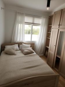 Un dormitorio con una cama grande con ventana. en Maison Nouvelle Route Carrossel, en Yaoundé