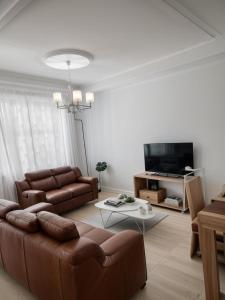Una sala de estar con un sofá y un televisor. en Maison Nouvelle Route Carrossel, en Yaoundé 3 fotos más