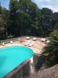 a swimming pool with two lounge chairs and a patio at Casarão imperador in Guapimirim