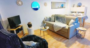 a living room with a couch and a tv at Face Mer Parking 4 personnes wifi in Berck-sur-Mer