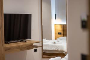 a room with a television and a bed in a mirror at BB The Garden in Durrës