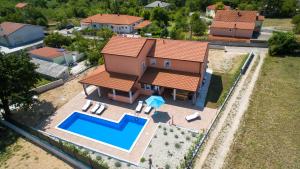 an aerial view of a house with a swimming pool at Villa Lavanda with relaxation spot of swimming pool in scented garden, outdoor terrace and barbecue in Tribalj
