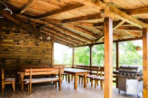 a room with wooden tables and benches in a cabin at Villa Kashtata in Resilovo