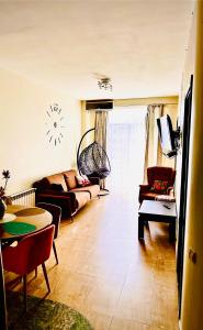 Una sala de estar con un sofá y un reloj en la pared. en Batumi Center 3 Rooms City Side, en Batumi