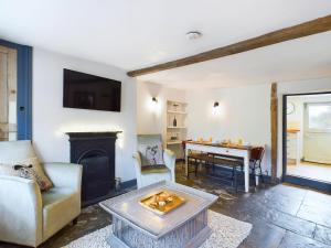 a living room with a fireplace and a table at Cosy Cottage in Moreton-in-Marsh in Moreton in Marsh