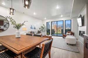 a kitchen and living room with a wooden table and chairs at Ski and Greens Haven Pt A107 in Eden