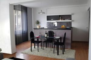 a black dining room table with black chairs in a kitchen at Apartment CenterLux in Sarajevo