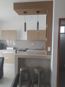 a kitchen with two stools sitting next to a counter at Departamento Granada in Huanchaco