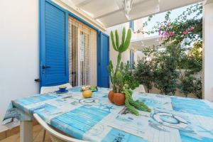 une salle à manger avec une table bleue et un cactus dans l'établissement Residence Blu Mare, à San Vito Lo Capo