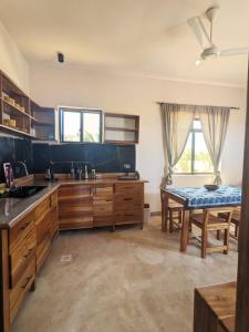 a large kitchen with wooden cabinets and a table at Alcyone Residence - Ocean View Villa in Muyuni