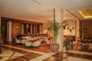 a lobby with chairs and tables and a bar at Real Marina Hotel & Spa in Olhão