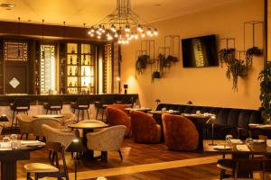 a restaurant with tables and chairs and a chandelier at Real Marina Hotel & Spa in Olhão