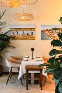 a dining room with a table and paintings on the wall at Real Marina Hotel & Spa in Olhão