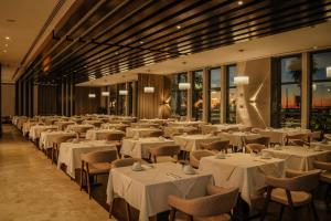 a banquet hall with white tables and chairs at Real Marina Hotel & Spa in Olhão