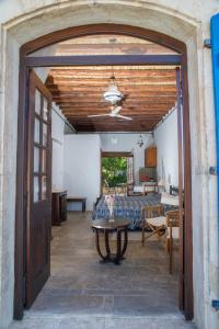 eine offene Tür zu einem Schlafzimmer mit einem Bett und einem Tisch in der Unterkunft Sappho Manor House in Dhrousha