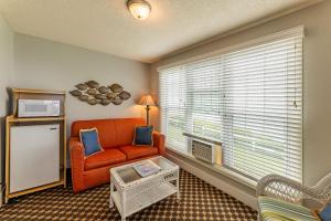 a living room with an orange chair and a window at Michillinda Lodge Resort in Whitehall