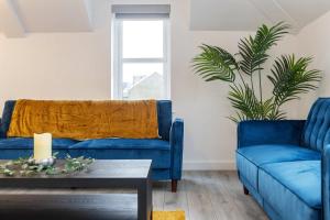 a living room with two blue couches and a table at Unique 1 bed Penthouse in East Village, Belfast - Walk to City Centre, Roof Terrace in Belfast