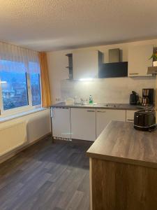 Una cocina con gabinetes blancos y encimera. en Pension Bergterrasse, en Sitzendorf